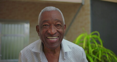 Elderly African American man smiling warmly at the camera, radiating joy and positivity in an...