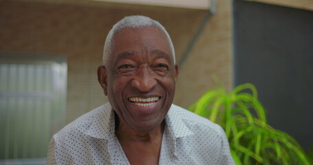 Elderly African American man smiling warmly at the camera, radiating joy and positivity in an...