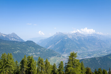 This landscape photo was taken in Europe, Switzerland, Valais, in summer. It shows the Rhone Valley in Switzerland, under the Sun.