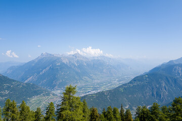 This landscape photo was taken in Europe, Switzerland, Valais, in summer. It shows the Rhone Valley in Switzerland, under the Sun.