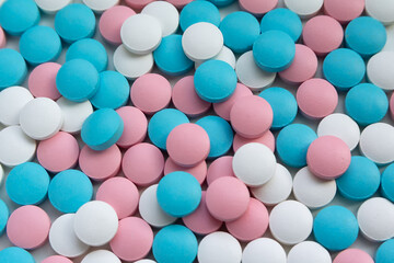 White, blue and pink tablets scattering on the table