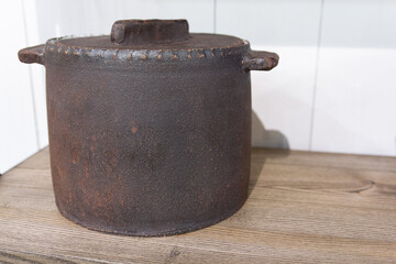 Rustic, aged cast iron pot with lid and handles,