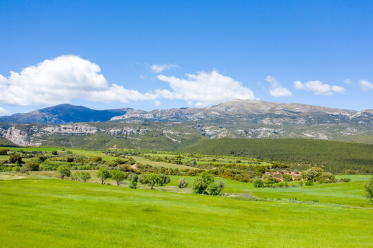 This landscape photo was taken in Europe, Spain, Aragon, Huesca, Samitier, in summer. It shows the fields and mountains around Bierge, under the Sun.