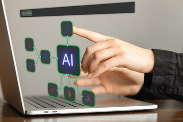 A person is pointing at the word AI on a laptop