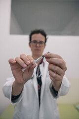 Female Doctor Preparing Syringe for Injection in Medical Setting