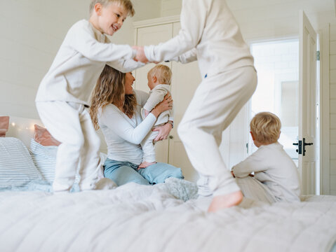 Young boys playing on the bed jumping