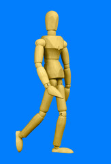 A wooden mannequin figurine closeup isolated on a blue background