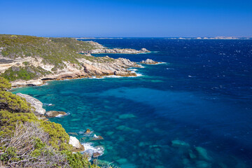 the coastline of cap Pertusato with deep blue turquoise sea and a view of Lavezzi island under a sunny blue sky © mschauer