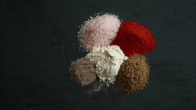 collection of spices salt paprika garlic powder black pepper on dark background close up