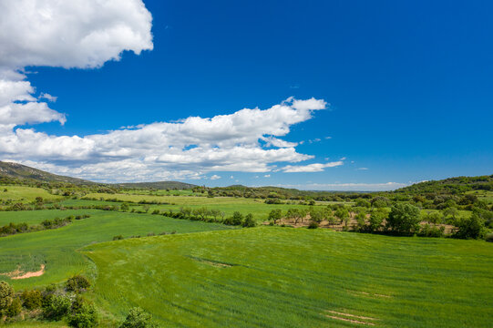This landscape photo was taken in Europe, Spain, Aragon, Huesca, Samitier, in summer. It shows the fields and mountains around Bierge, under the Sun.