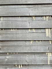 Rustic wooden fence closeup, horizontal overlapping planks and visible paint droplets. Natural grain makes it excellent background or texture for design, craft, and architectural projects.