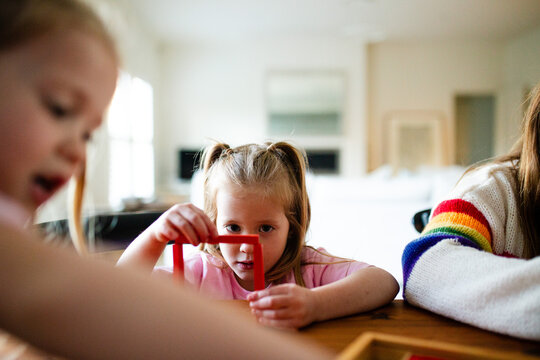 Young girls playing colourful rectangular blocks on the table