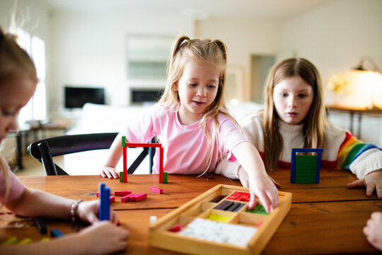 Young girls playing colourful rectangular blocks on the table