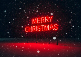 Neon merry christmas sign illuminated against snowfall
