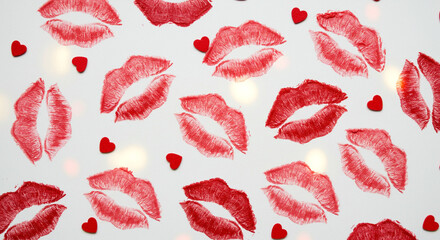 Red lipstick kiss marks and small red hearts on white background, romantic festive decoration