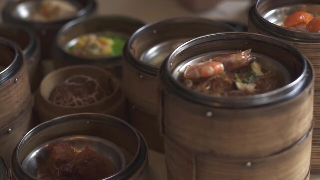 A close-up shot of various dim sum dishes served in traditional bamboo steamers at Dim Sum restaurant. Cinematic lighting. Delicious dim sum, Chinese food.