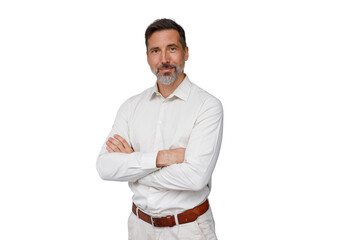 Mature man standing confidently, smiling with arms crossed, wearing a white shirt and light pants....