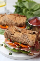 Tasty ciabatta sandwiches served on white table, closeup