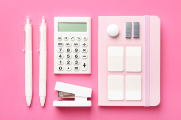 Stapler and other stationery on pink background, flat lay