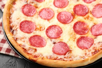 Delicious pepperoni pizza on black background, closeup