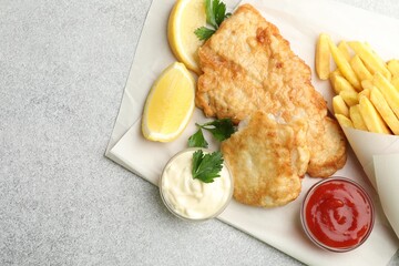 British Traditional Fish and chips served with sauces on light grey table, flat lay. Space for text