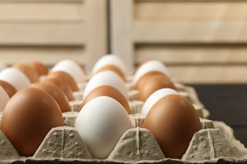 Fototapete Zu Essen Many raw chicken eggs in carton on table indoors, closeup  © New Africa