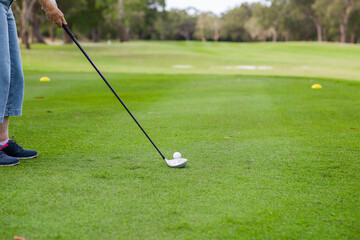 woman lining up to tee off on a golf course