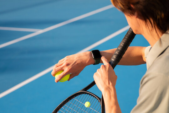 asian man checking his fitness smartwatch at tennis
