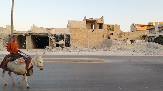 Syrian Kid boy rides a donkey through a street in war-torn Aleppo, with destroyed buildings in the background, symbolizing resilience, childhood innocence, and survival amid the Syrian civil war.