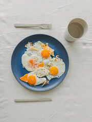 A Delicious and Appetizing Breakfast Plate that Features Fried Eggs on a Beautiful Blue Dish