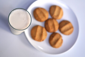 Freshly Baked Biscuits and fresh milk glass on White Plate Isolated Background.