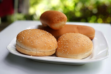 Hamburger and hot dog buns on white plate isolated on white background.