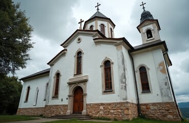 Holy Trinity Church exterior view under cloudy sky. Catholic church architecture with towers, crosses and a bell tower. Old religious building with stone foundation is landmark for tourists.