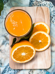 A glass of fresh orange juice with whole oranges placed beside it, refreshing and full of vitamin C, perfect for breakfast or a healthy lifestyle concept.