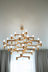 A golden chandelier with many light bulbs. Style, minimalism and luxury,
