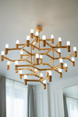 A golden chandelier with many light bulbs. Style, minimalism and luxury,