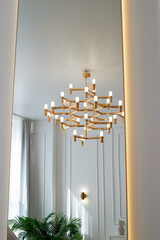 A golden chandelier with many light bulbs. Style, minimalism and luxury,
