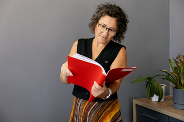 Woman reading a red binder in a casual office setting