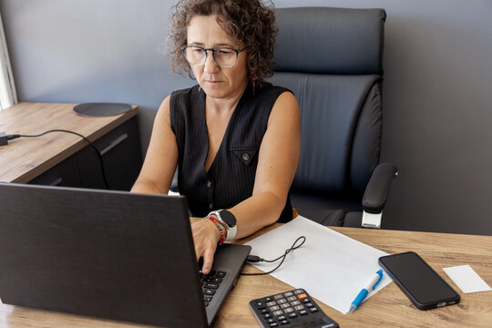 Focused professional working at her desk with a laptop