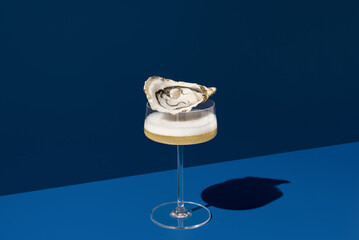 Champagne glass with oyster on blue background