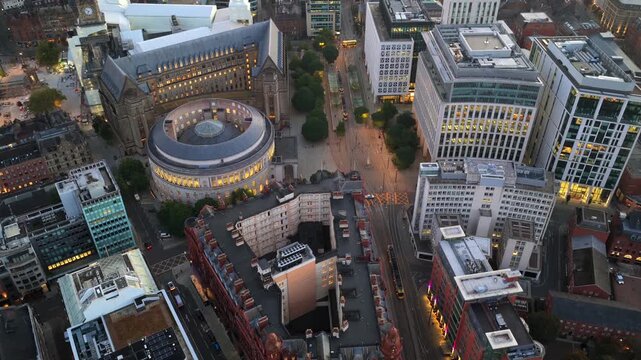 Top-down aerial video of a tram travelling towards St Peter&rsquo;s Square and Manchester downtown area at Dawn.
