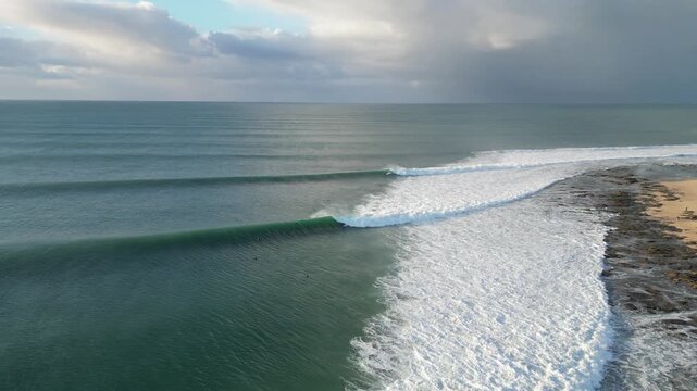 Aerial view of ocean waves with surfers surfing at Supertubes in Jeffreys Bay or J-Bay in South Africa