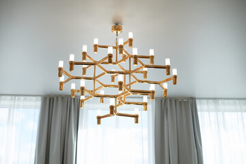 A golden chandelier with many light bulbs. Style, minimalism and luxury,