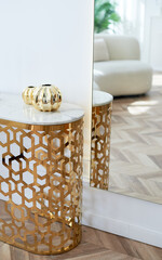 A table with a metallic gold underframe. Luxurious minimalist interior. White and gold palette,