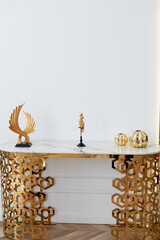 A table with a metallic gold underframe. Luxurious minimalist interior. White and gold palette,