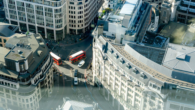Fototapeta Red buses crossing busy street in London's City District