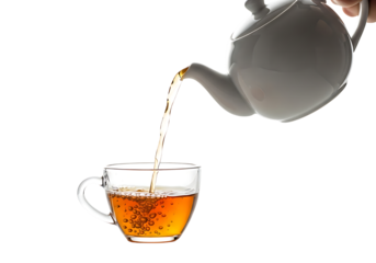 A hand pours hot tea from a white teapot into a clear glass mug isolated on transparent background