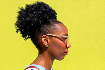Profile of a woman with curly hair and glasses