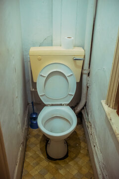Interior of an abandoned bathroom with vintage toilet