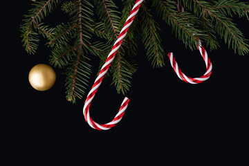 Sweets and branches on black background for New Year